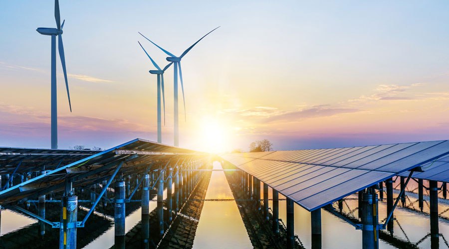 Solarzellen- und Windräderfeld bei Sonnenuntergang